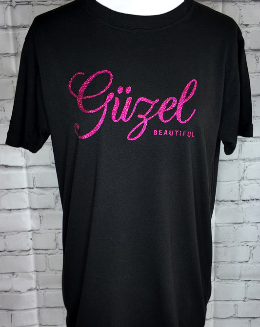 "Güzel" T-shirt in black with fuscia glitter print, front view